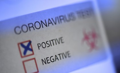 Label with a red box with a cross in it, indicating a positive COVID test result